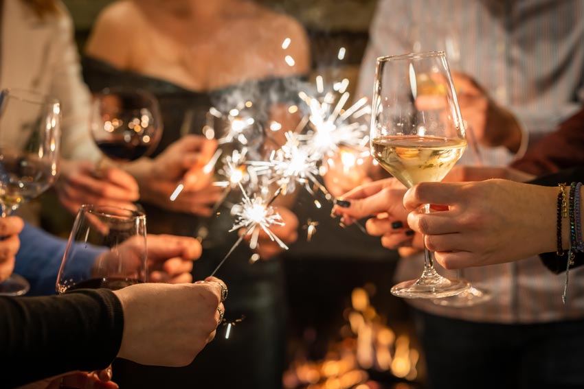 Weihnachtliche Stimmung mit Sternspritzern und es wird mit Wein angestoßen.