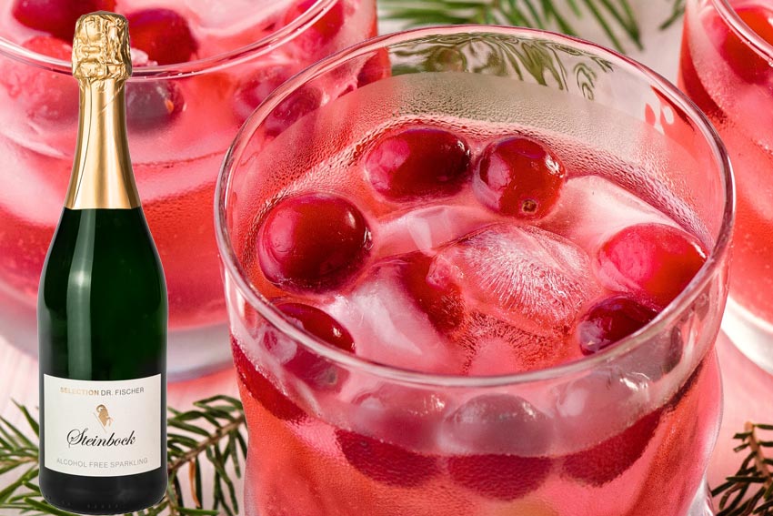 Eine Flasche Steinbcok Sparkling zero und ein Cranberry-Mimosa-Cocktail